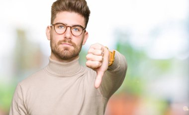 Mutsuz ve kızgın ret gösterilen ve başparmak aşağı hareketi ile negatif seyir gözlüklü genç yakışıklı iş adamı. Kötü ifade.