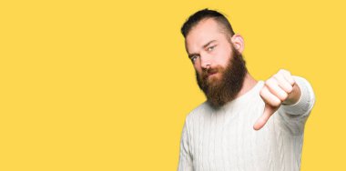 Genç hipster adam kış kazak giyen mutsuz ve kızgın gösteren reddi gösteren ve başparmak aşağı jest ile negatif. Kötü ifade.