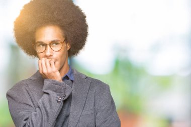Genç Afro-Amerikalı iş adamı afro saçlı gözlüklü stresli ve gergin elle çivi ısırma ağzına bakıyor. Anksiyete sorunu.