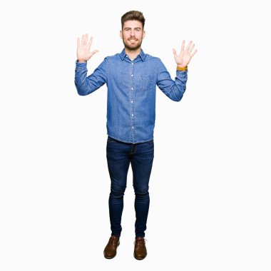 Genç yakışıklı sarışın adam gösteren ve parmak sayısı on ile işaret rahat denim gömlek giyen emin ve mutlu gülümseyen.