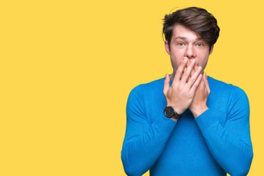 Üzerinde mavi kazak giyen genç yakışıklı adam arka plan ağız hata için elleriyle kapsayan şok izole. Gizli kavramı.