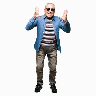 Kot ceket ve güneş gözlüğü giyen yakışıklı kıdemli adam silah ile başarı için deli ve çılgın kutluyor kaldırdı ve heyecanlı çığlık kapalı gözleri. Kazanan kavramı