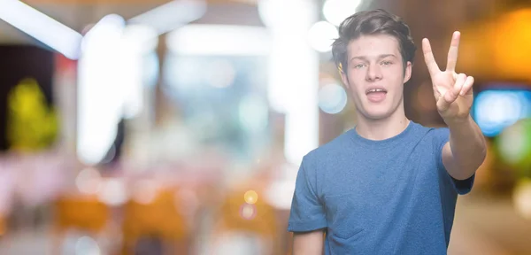Pemuda Tampan Mengenakan Kaos Biru Atas Latar Belakang Terisolasi Menunjukkan — Stok Foto