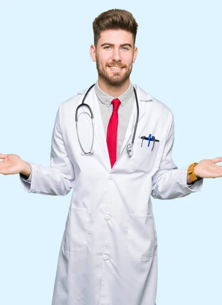 Jovem Bonito Médico Homem Vestindo Casaco Médico Sorrindo Mostrando Ambas — Fotografia de Stock