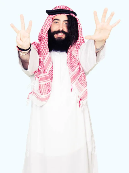 阿拉伯商人长头发 戴着传统的 Keffieh 一边用手指指着八号 一边微笑着自信和快乐 — 图库照片