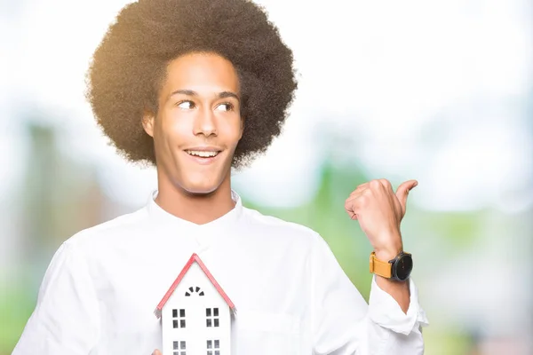 Joven Afroamericano Con Pelo Afro Sosteniendo Casa Señalando Mostrando Con —  Fotos de Stock