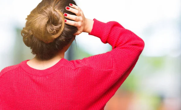 Kırmızı kazak ve çörek geriye düşünme hakkında şüphe el ile kafasına giyen genç güzel kadın