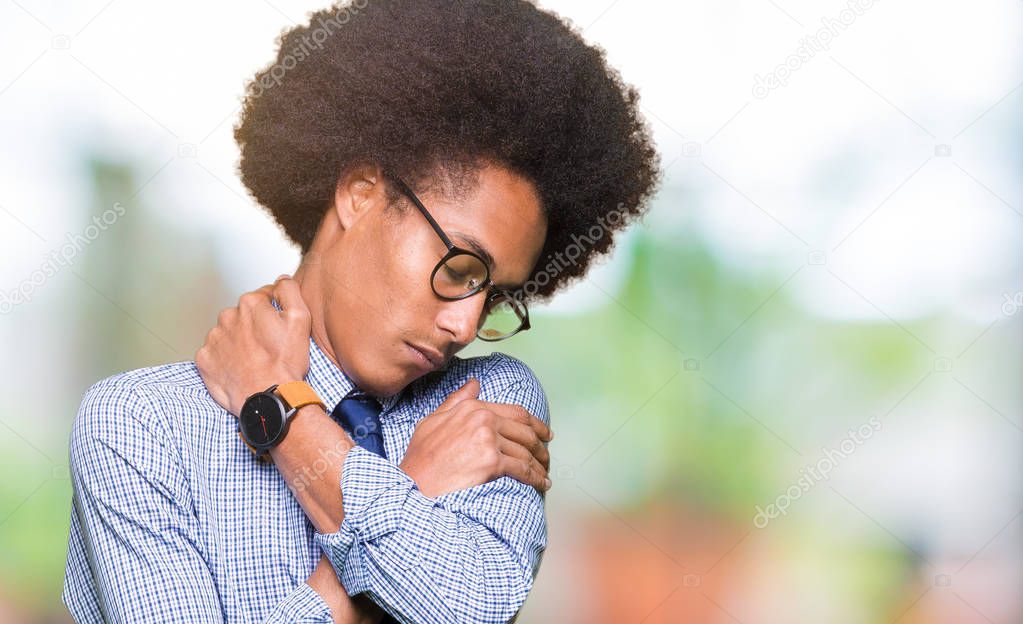 Young african american business man with afro hair wearing glasses Hugging oneself happy and positive, smiling confident. Self love and self care