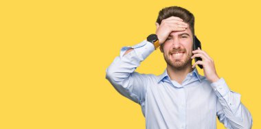 Genç yakışıklı adam iş başında, el ile vurguladı smartphone cep telefonu ile konuşurken şok utanç ve sürpriz suratla, öfkeli ve sinirli. Korku ve hata için üzgün.