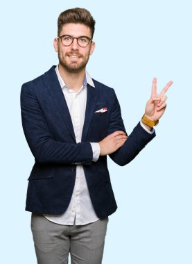 Mutlu yüz zafer işareti yaparken kameraya göz kırpıyor ile gülümseyen gözlüklü genç yakışıklı iş adamı. İki numaralı.