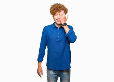 El yüz ve sürpriz duygu kendinden emin gülümseme ile tek gözüyle kapsayan afro saçlı Genç yakışıklı zarif adam.