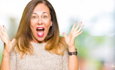 Güzel orta yaş kadın giyiyor moda kazak kaldırdı Kollarını açarak çılgın ve başarı için hayran kutluyor ve açık gözleri heyecanlı çığlık. Kazanan kavramı