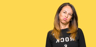 Komik surat ile yanakları şişirme rock and roll kazak giyen güzel orta yaş kadın. Ağız ile hava, deli ifade şişirilmiş.