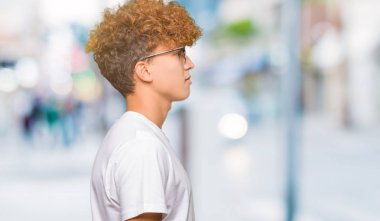 Tarafına, seyir güneş gözlüğü takıyor afro saçlı Genç yakışıklı adam sakin ol kendine güvenen gülümseme ile doğal yüz pozuyla profili.