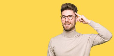 Bir parmak, harika bir fikir ya da düşünce, iyi bellek ile baş gösteren gülen genç yakışıklı iş adamı giyen gözlük