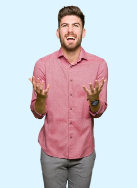 Genç yakışıklı iş casual adam çılgın ve kızgın bağırarak ve agresif ifade ve silah kaldırdı bağırıyordu. Hayal kırıklığı kavramı.