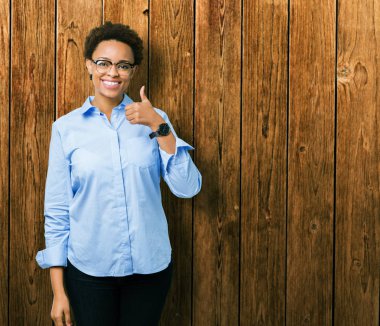 Genç güzel Afro-Amerikan iş kadın hareketi el ile mutlu yaşasın yapıyor izole arka plan yüzünden. Başarı gösteren kameraya bakarak ifade onaylama.