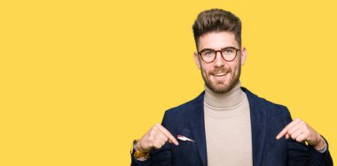 Yüzünde gülümseme ile kendinden emin görünüyorsun, kendini gururlu ve mutlu parmakları ile işaret gözlüklü genç yakışıklı iş adamı.