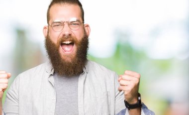 Kutluyor gözlük takan genç sarışın adam şaşırttı ve silah ile başarı için yükseltilmiş ve açık gözler hayrete düşürdü. Kazanan kavramı.