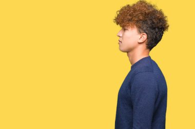 Genç yakışıklı adam ile afro saç arıyor yan, dinlenmek profil poz doğal yüz ile emin gülümseme.