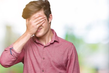 Genç yakışıklı iş adamı gülümsüyor ve gözleri için sürpriz kapsayan yüz el ile gülüyor izole arka plan üzerinde. Kör kavramı.