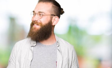 İki elin avuç içi açık gösterilen, sunma ve karşılaştırma ve denge reklam gülen giyen genç sarışın adam gözlük