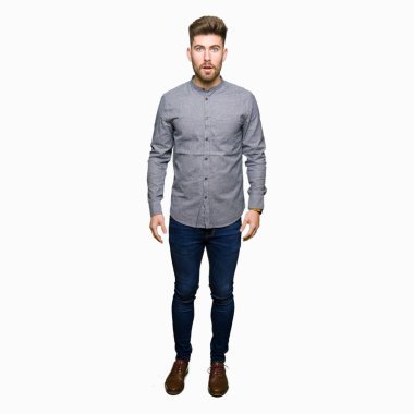 Genç yakışıklı iş casual adam korkuyor ve sürpriz ifade, korku ve heyecan yüz ile şok.