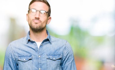 Yakışıklı adam gözlük takan yan bakıyor gülümseyerek ve düşünme uzak bakıyor.