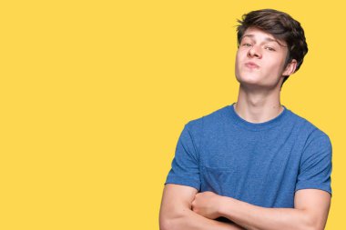 Görünümlü yan ve dik dik bakma uzağa düşünce gülümseyen izole arka plan üzerinde mavi t-shirt giyen genç yakışıklı adam.