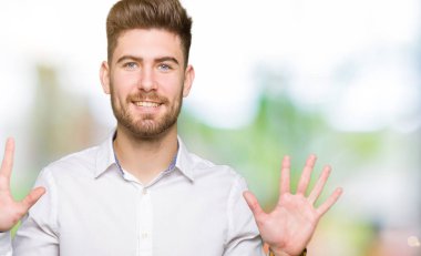 Gösterilen ve parmakları ile işaret genç yakışıklı iş adamı kendinden emin ve mutlu gülümseyerek süre on numara.