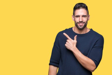 İzole arka neşeli bir gülümseme ile el ve parmak kadar yan yüzünde mutlu ve doğal ifade ile işaret yüz üzerinden kazak giyen genç yakışıklı adam