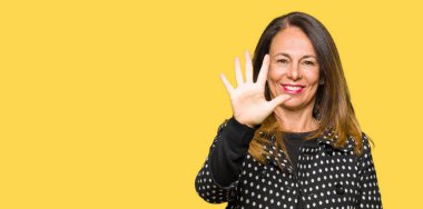 Kendinden emin ve mutlu gülümseyerek süre beş numara gösterilen ve parmakları ile işaret güzel orta yaş kadın giyiyor moda ceket.