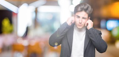 Yüksek sesle müzik gürültü rahatsız ifade parmaklarıyla kulaklarıyla kapsayan izole arka plan üzerinde kış palto giyiyor zarif delikanlı. Sağır kavramı.