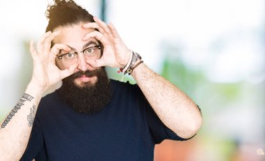 Uzun saç ve sakal parmaklarıyla, Uykulu ve sabah yorgunluk için yorgun gözlerini açmaya çalışırken gözlüklü genç hipster adamla