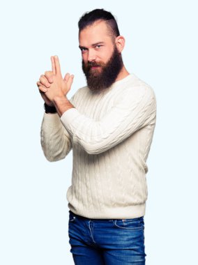 El hareketi ile sembolik silah tutan, çekim silah, kızgın yüz öldürmek oynamaya kış kazak giyen genç hipster adam