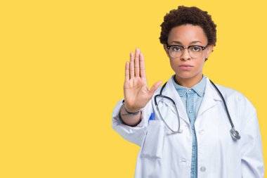 Stop yapıyor izole arka plan üzerinde tıbbi ceket giyen genç Afro-Amerikan doktor kadın elin avuç ile şarkı. Negatif ve ciddi bir jest yüz ifadesiyle uyarı.