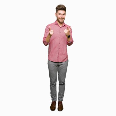 Genç yakışıklı iş casual adam kameraya mutlu ve komik suratla parmakları işaret. İyi enerji ve vibes.