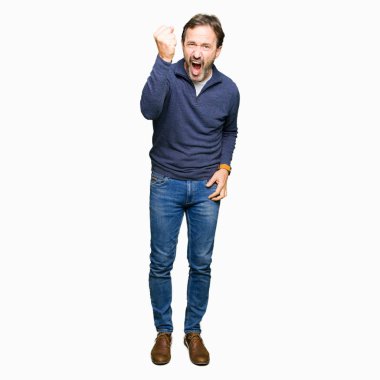 Orta yaş yakışıklı adam kızgın ve kızgın hayal kırıklığı ve öfke ile bağırarak süre öfkeli yumruk yükselterek bir kazak giyiyor. Öfke ve agresif kavramı.