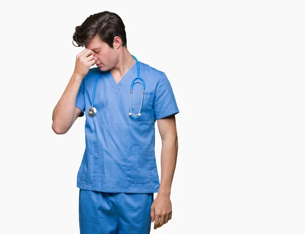 年轻的医生穿着医疗制服在孤立的背景疲劳摩擦鼻子和眼睛感到疲劳和头痛 压力和挫折的概念 — 图库照片