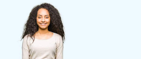 Young beautiful girl with curly hair wearing casual sweater with a happy and cool smile on face. Lucky person.