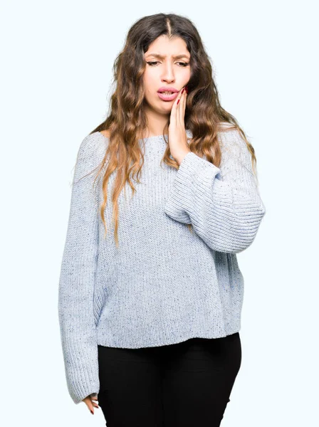 Diş ağrısı veya dişlerde dişlerle ilgili hastalık nedeniyle ağız acı ifadesi ile el ile dokunmak kış kazak giyen genç güzel kadın. Diş hekimi kavramı.