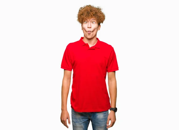 年轻英俊的男子与非洲头发穿着红色的 T恤做鱼脸与嘴唇 疯狂和滑稽的姿态 有趣的表情 — 图库照片
