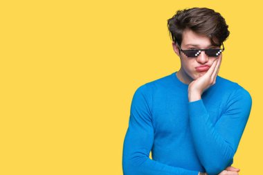 Genç adam komik thug hayat gözlüklü düşünme izole arka plan bakmaktan yorgun ve sıkılmış çapraz silah depresyon sorunları ile.