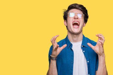 Yakışıklı delikanlı deli ve silah ile başarı için deli kutluyor izole arka plan üzerinde gözlük takan kaldırdı ve heyecanlı çığlık gözler kapalı. Kazanan kavramı