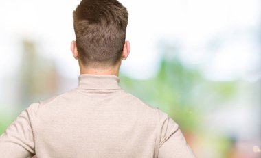 Genç yakışıklı iş adamı gözlük takan geriye doğru vücut kolları ile uzağa bakarak ayakta