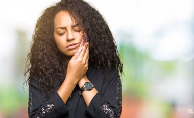 Kıvırcık saçlı Genç güzel kız diş ağrısı ya da diş hastalıkları nedeniyle ağrılı ifade ile elle dokunan zarif elbise giyen ağız. Dişçi konsepti.