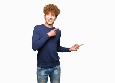 Gülümseyen ve iki ile işaret kamera bakarak afro saçlı yakışıklı delikanlı eller ve yan parmak.