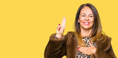 Göğüs ve bir sadakat sözü yemin yapma parmaklar, el ile Swearing güzel orta yaş zarif kadın giyiyor vizon ceket