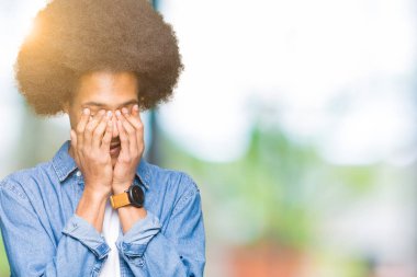 Üzgün ifadeyle yüz eller ile ağlayarak süre kapsayan afro saçlı genç Afro-Amerikan adam. Depresyon kavramı.