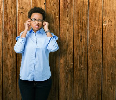 Yüksek sesle müzik gürültü için rahatsız ifade ile parmaklar ile izole arka plan üzerinde genç güzel Afrikalı Amerikan iş kadını. Sağır kavramı.